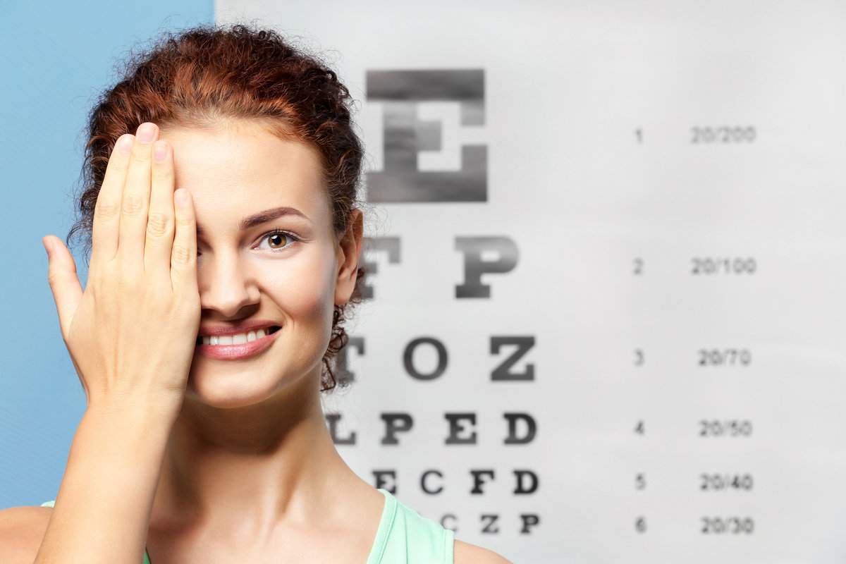 Young woman on eyesight test chart background