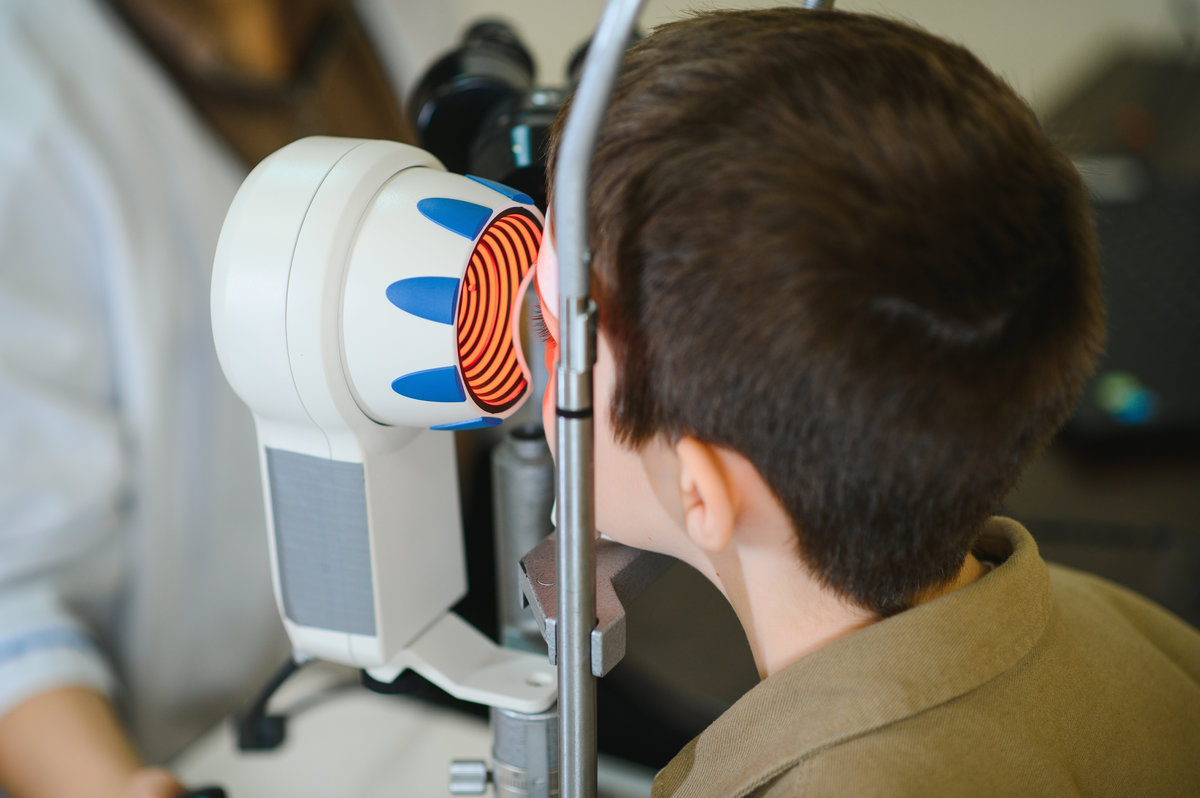 Ophthalmologist examining a child's eyesight with an autorefractor in a clinic, ensuring accurate vision diagnostics and care