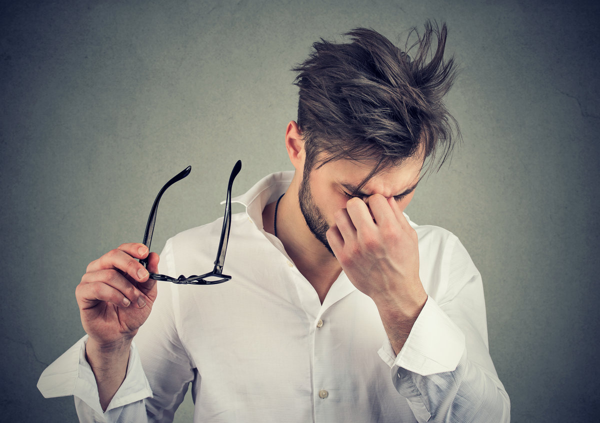 Young man with glasses suffering from eyestrain
