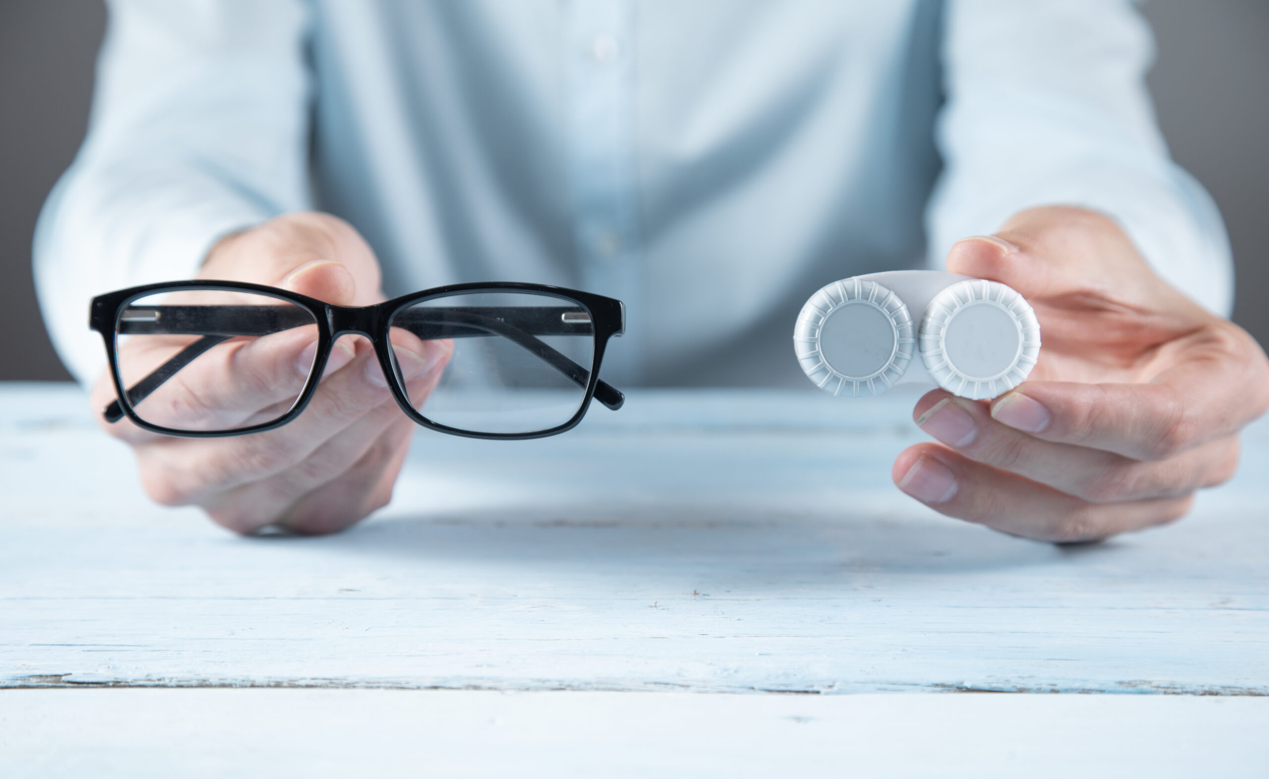 man hand lenses and glasses on the blue table