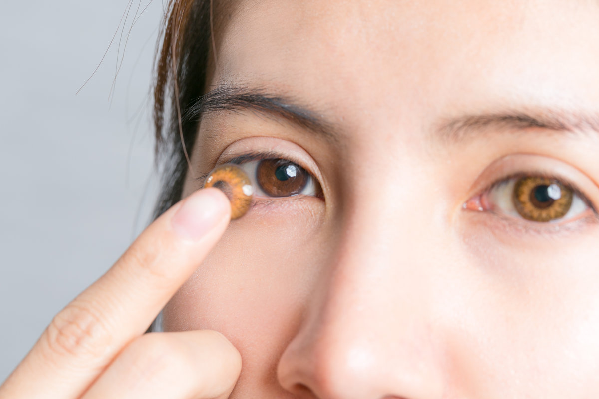Close-up shot of young woman wearing contact lens.
