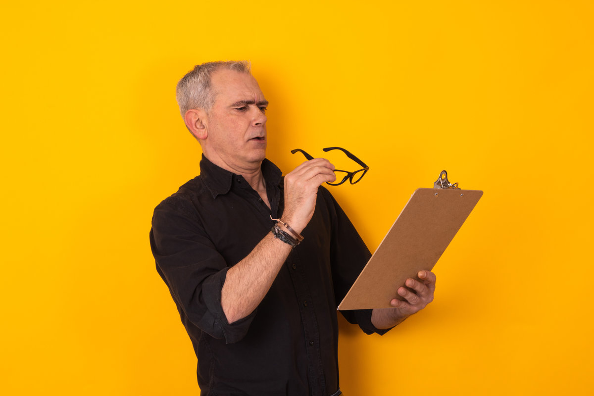 senior man looking at documents with difficulty