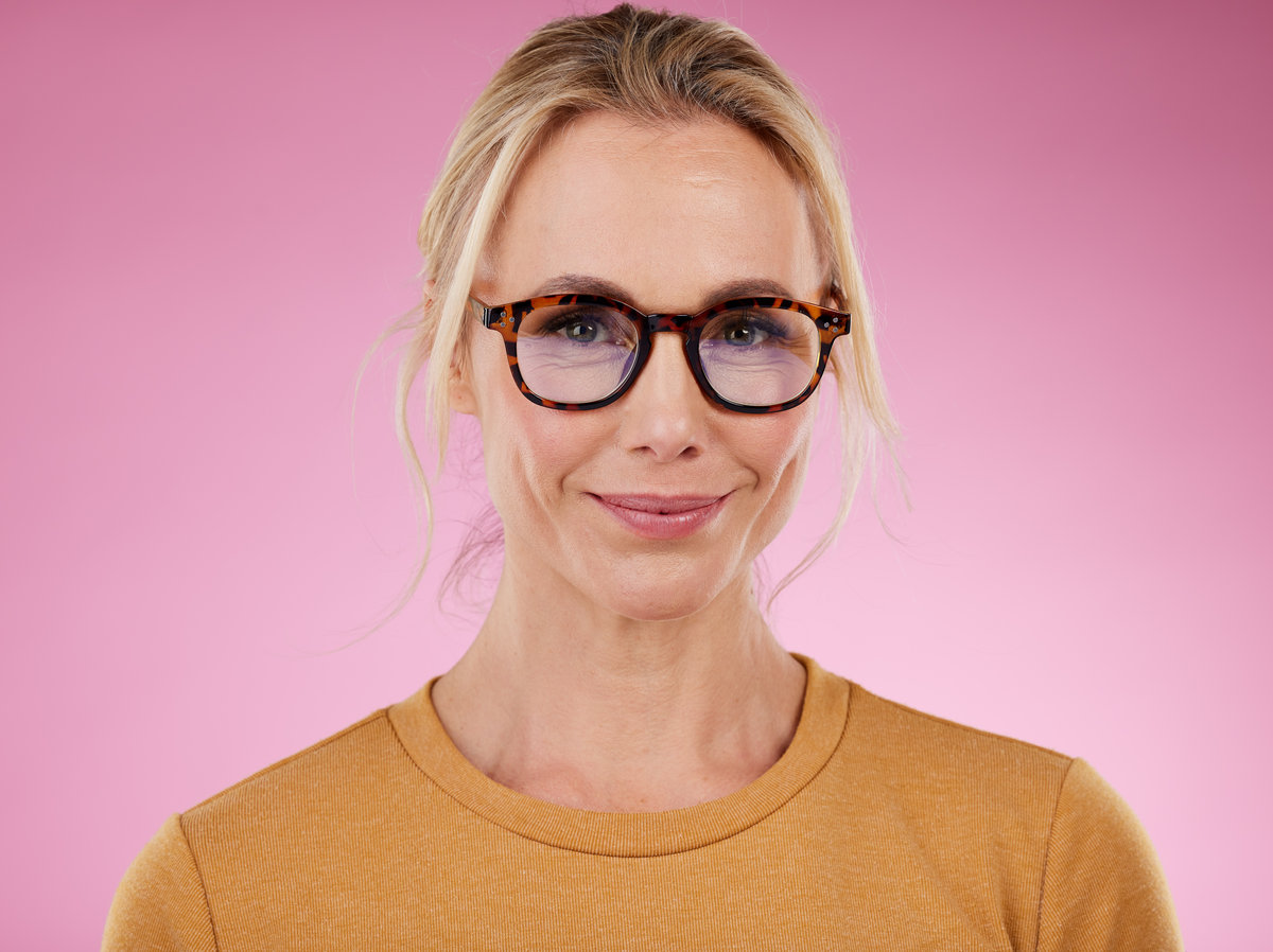 Woman, glasses style and portrait on pink background, studio backdrop and happiness. Happy female model, face and spectacles for fashion, eye care and vision of frames, cosmetic beauty or lens choice.