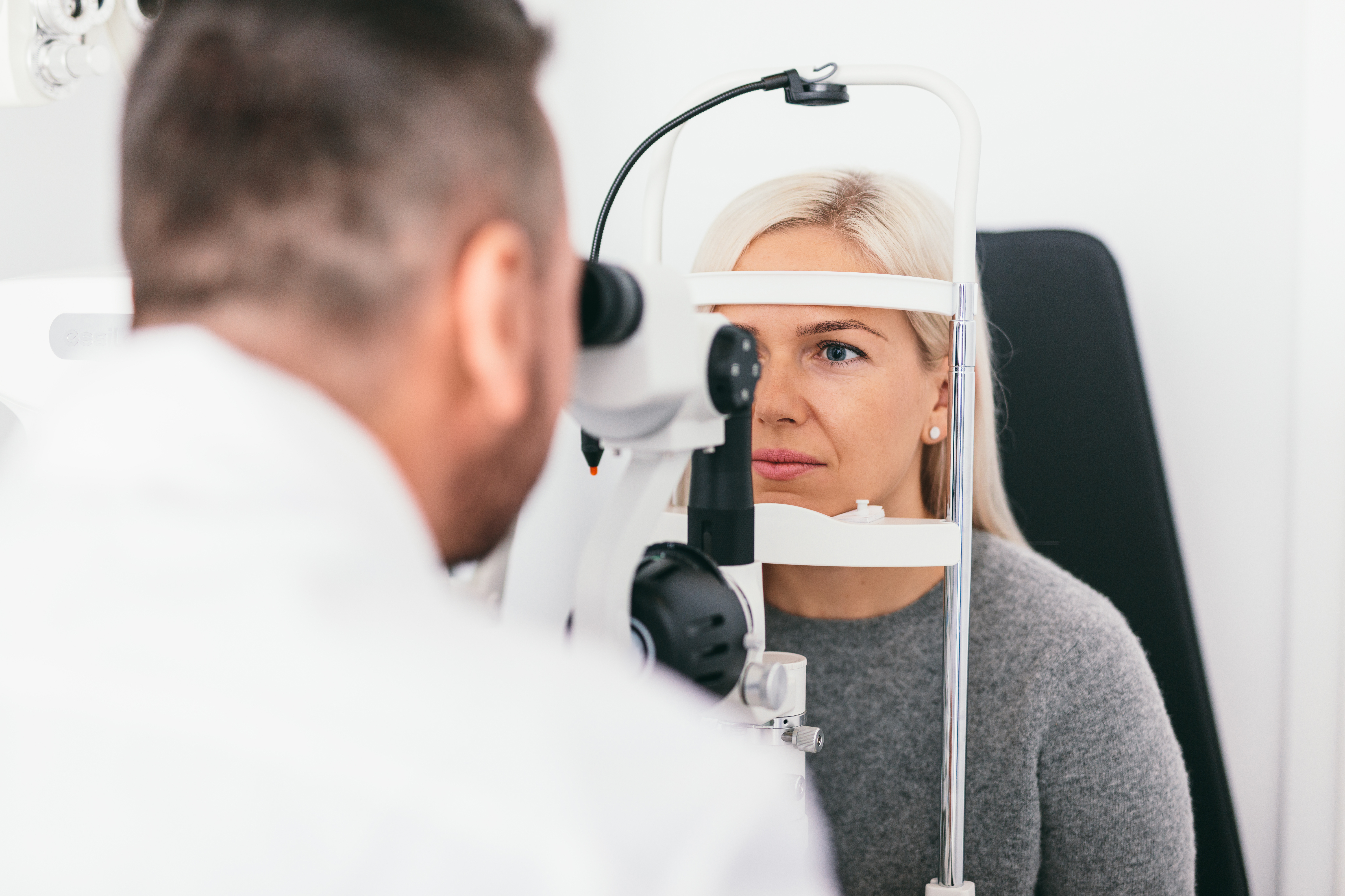 Woman undergoing eyesight exam in optician's office. Ophthalmology, vision examination and treatment.