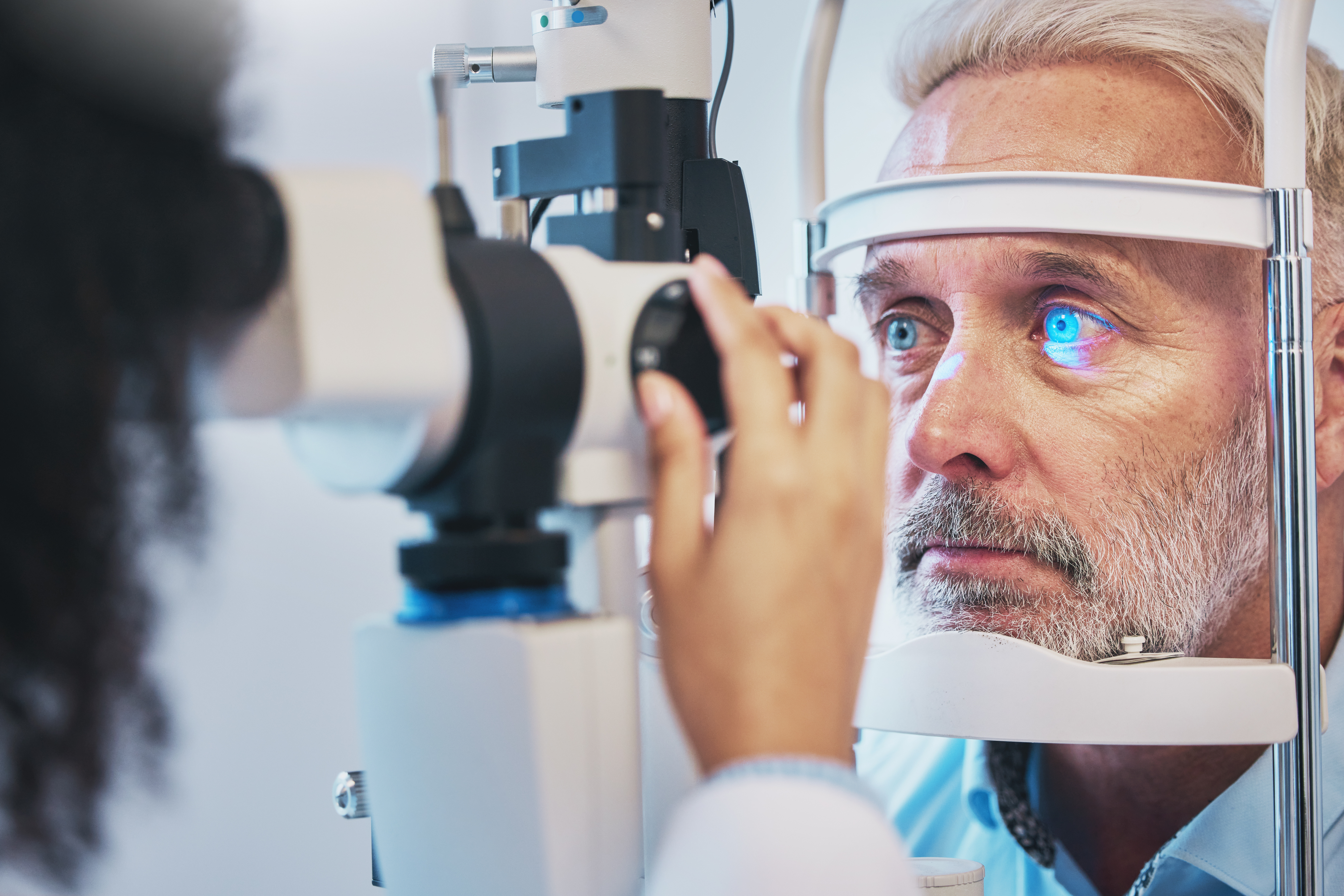 Ophthalmology, medical and eye exam with old man and consulting for vision, healthcare and glaucoma check. Laser, light and innovation with face of patient and machine for scanning and optometry.