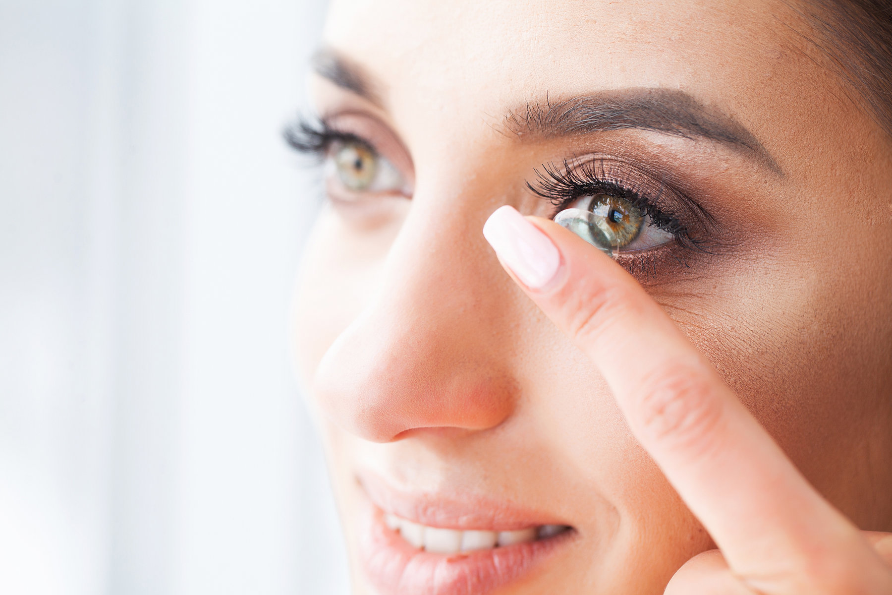 Vision concept. Close-up shot of young woman wearing contact lens.