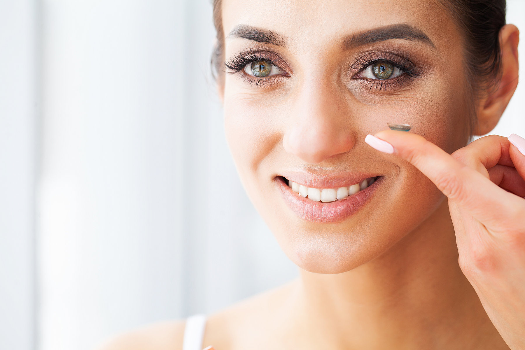 Vision concept. Close-up shot of young woman wearing contact lens.