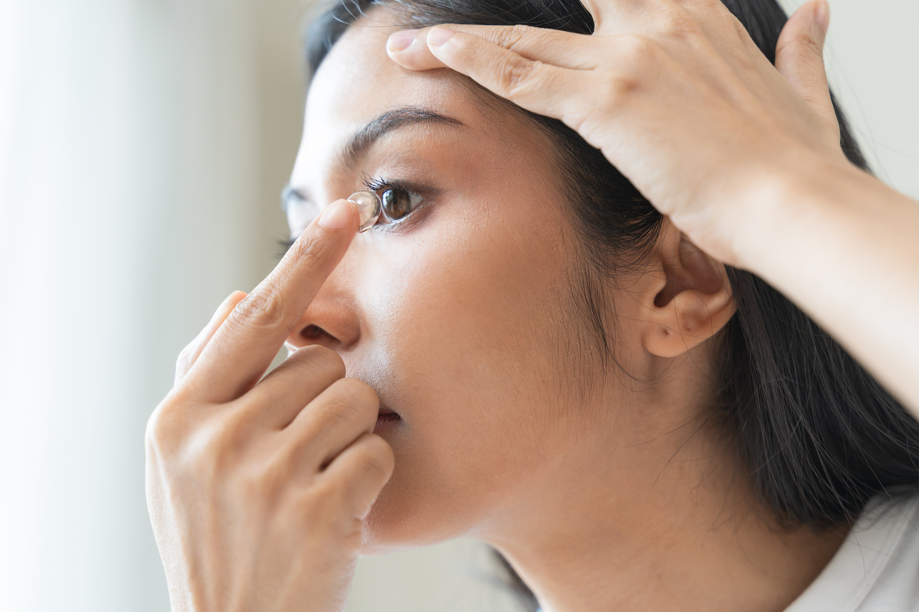 Optimise vision by contact lens, Close-up of woman face during insert contact lens to her eyes.